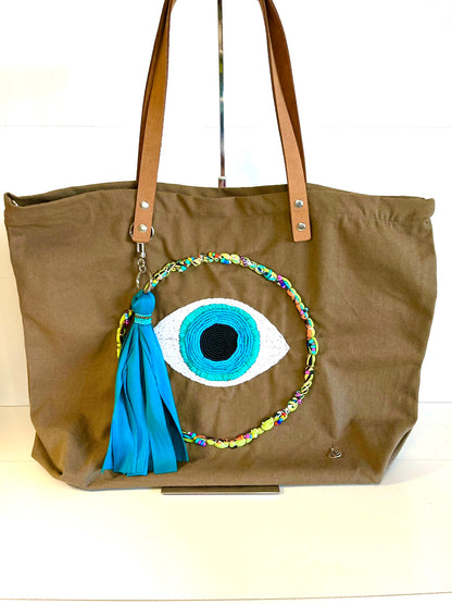 Fabric hand bag with embroidered eye and tassel